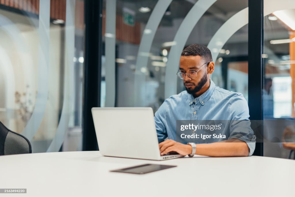 Cheerful businessman working on his laptop
