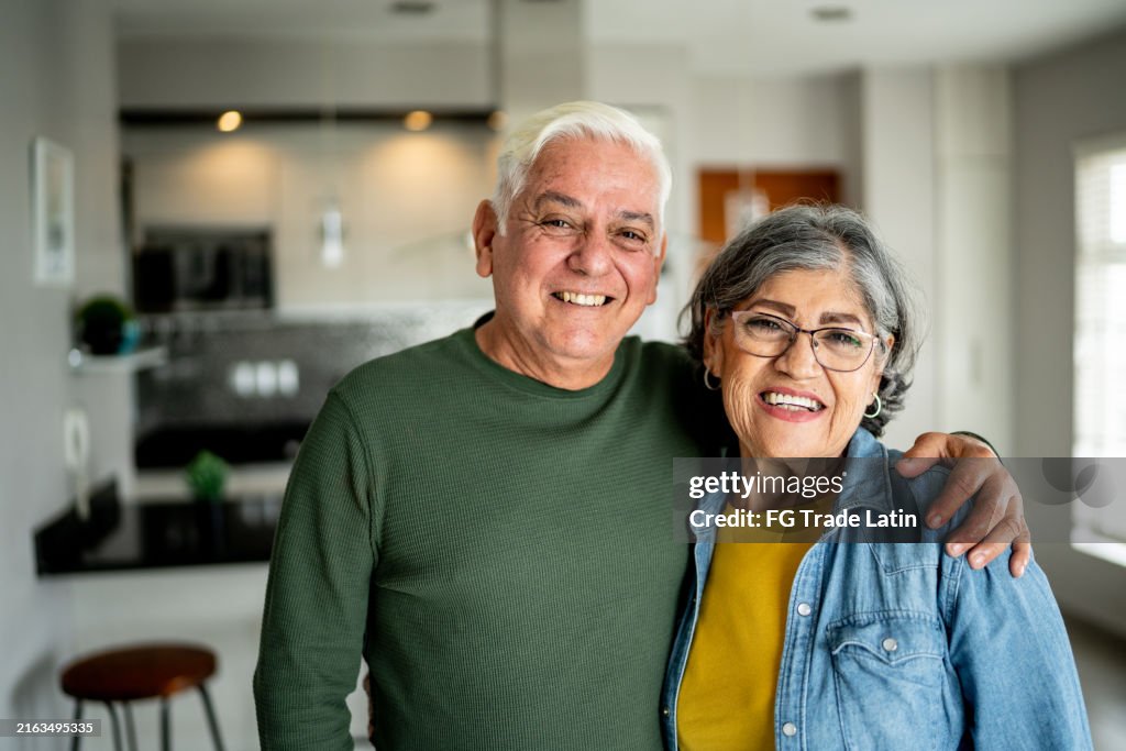 Porträt eines älteren Ehepaares, das sich zu Hause umarmt
