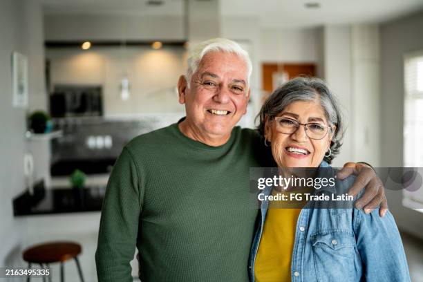 portrait of a senior couple embracing at home - husband stock pictures, royalty-free photos & images