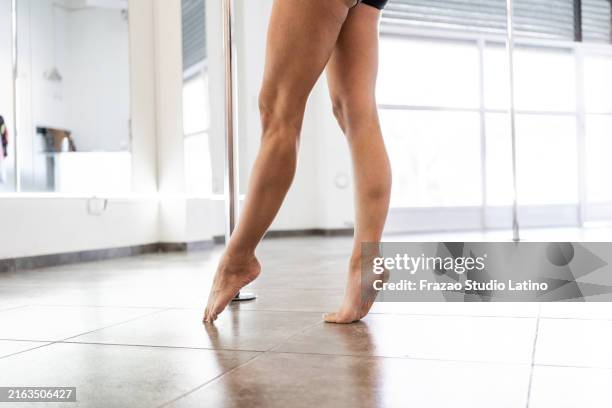 low section of woman dancing pole in a dance studio - pole dance stock pictures, royalty-free photos & images
