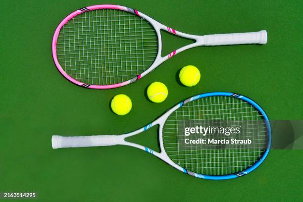 two rackets and tennis balls on a tennis court - racchetta da tennis foto e immagini stock