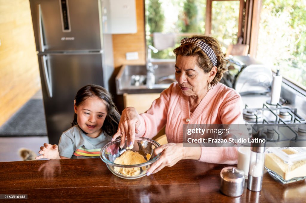 Großmutter backt Kuchen mit ihrer Enkelin in der Küche zu Hause