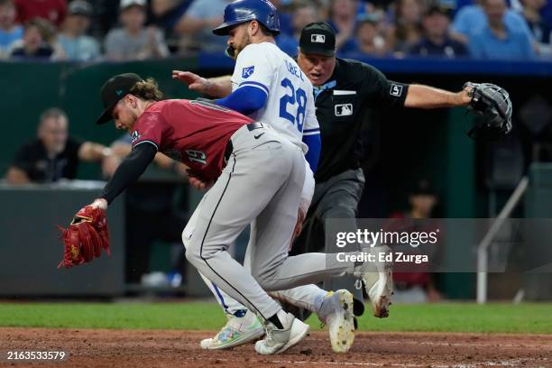 Kyle Isbel of the Kansas City Royals scores on a wild pitch by Ryne Nelson of the Arizona Diamondbacks as umpire Brian O'MacKay makes the call in the...