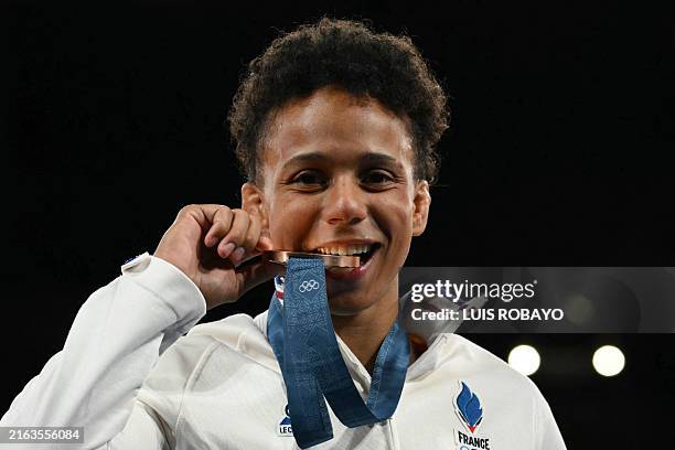 Bronze medallist France's Amandine Buchard celebrates on the podium of the the judo women's -52kg final bout of the Paris 2024 Olympic Games at the...