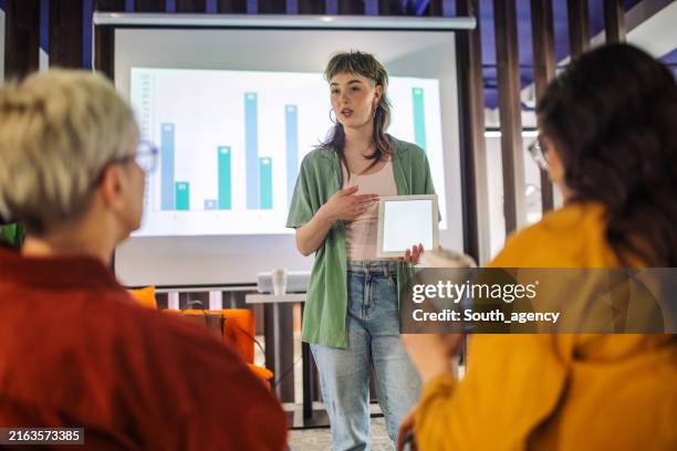 person presenting data on tablet in casual setting - knowledge graph stock pictures, royalty-free photos & images