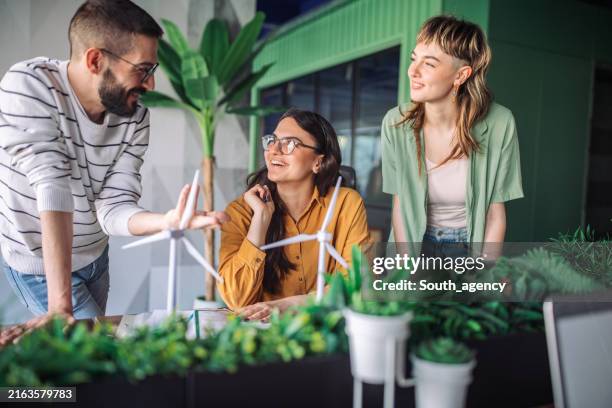 team members brainstorming wind turbine designs together. - sustainable lifestyle stock pictures, royalty-free photos & images