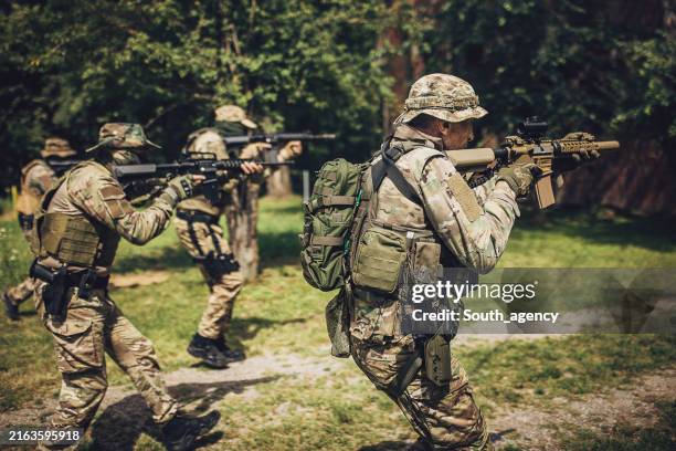 task force team advancing cautiously with rifles ready - rifle stock pictures, royalty-free photos & images