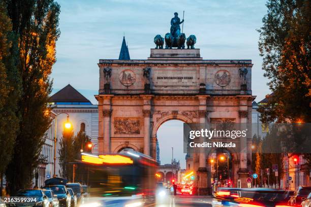 victory gate in munich with blurred light lines of traffic at blue hour - schwabing stock-fotos und bilder