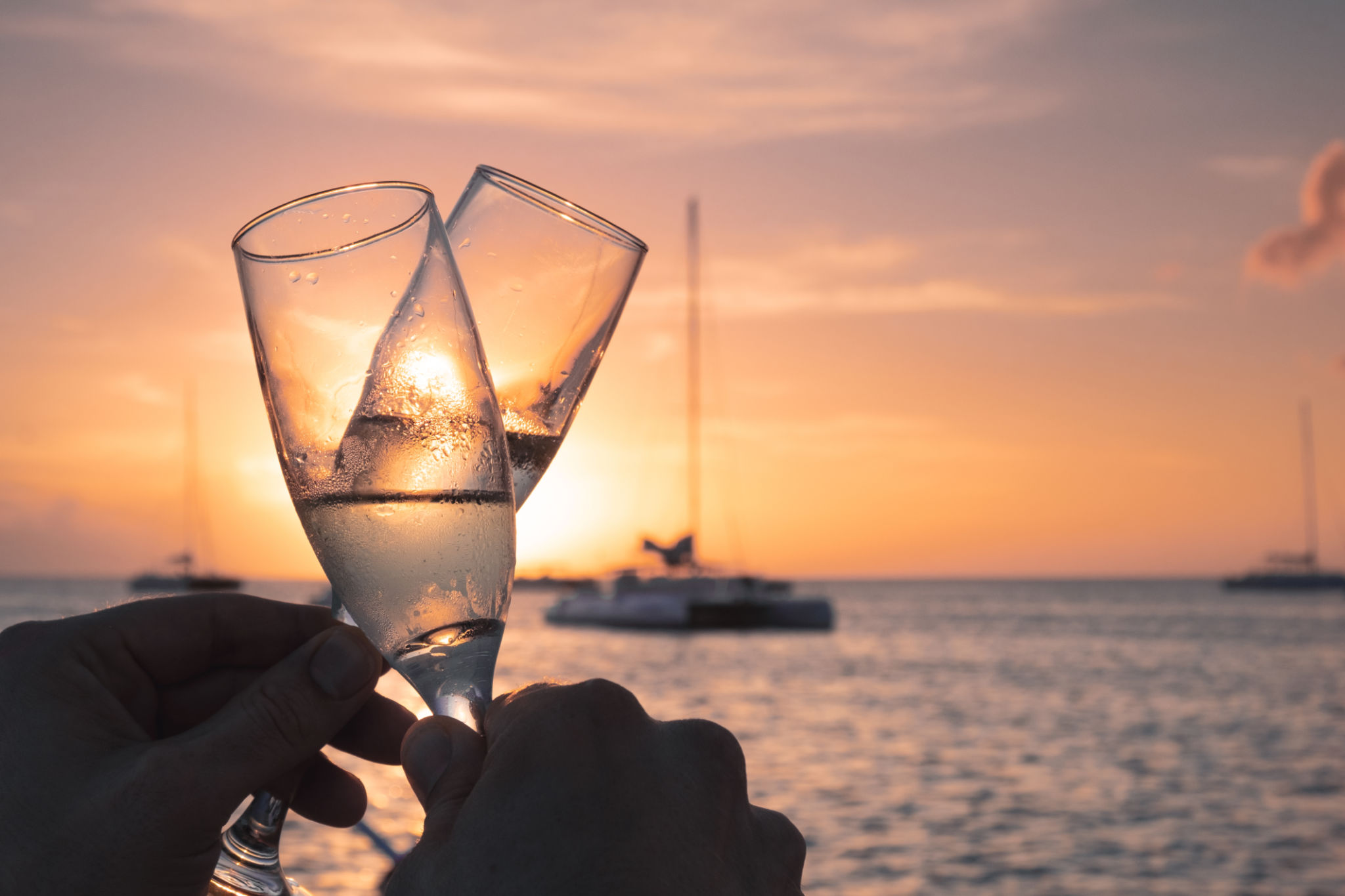 Close-Up Of Hand Holding Champagne Glass Against Sunset Sky Close-Up Of Hand Holding Champagne Glass Against Sunset Sky