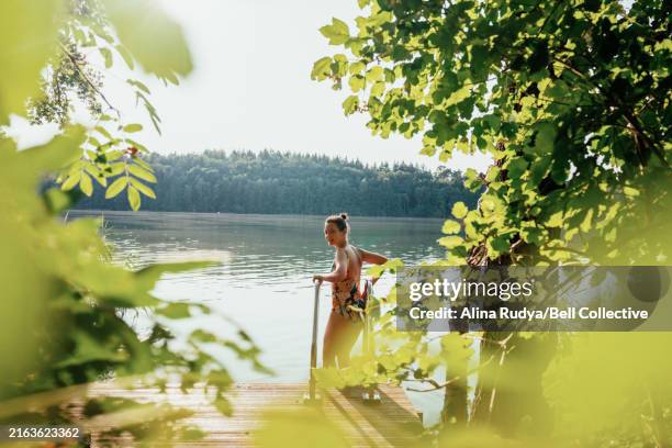 woman going onto a swim in a idyllic lake - lagoa imagens e fotografias de stock
