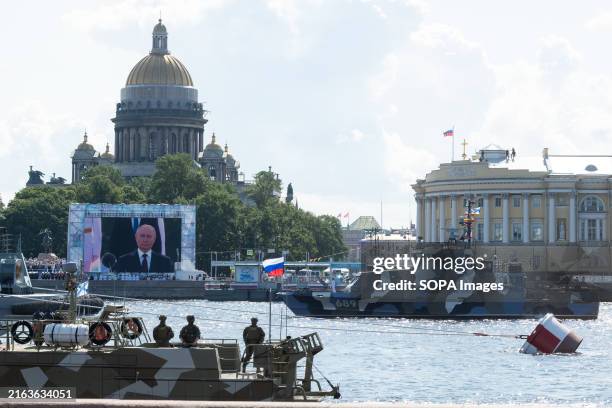 Russian warship sails along the Neva River during the annual Navy Day parade as Russian President Vladimir Putin delivers a speech broadcasted on a...