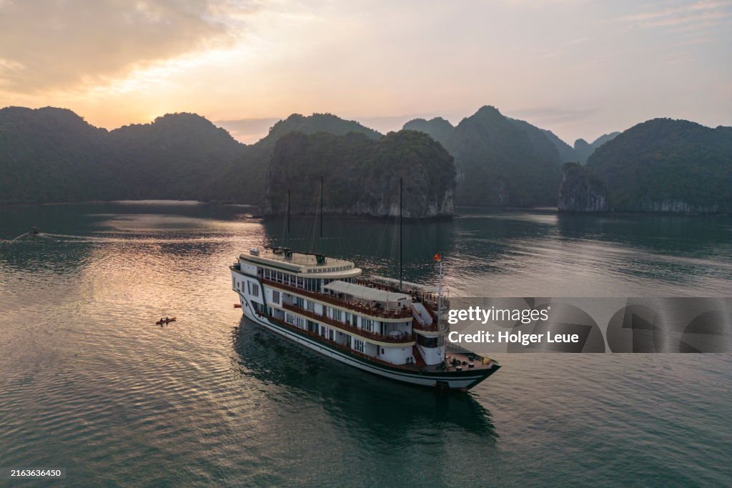 Aerial of boutique cruise ship Ylang (Heritage Line) with sea kayak at sunset