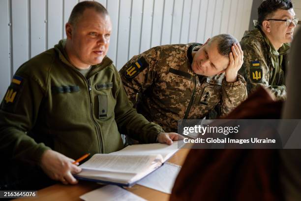 Servicemen talk with volunteers at the conscription point during sign a contract with the Ukrainian army on March 26, 2024 in Unspecified, Ukraine....