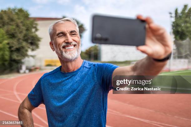 läufer im sportstadion macht selfie - leichtathletik stock-fotos und bilder