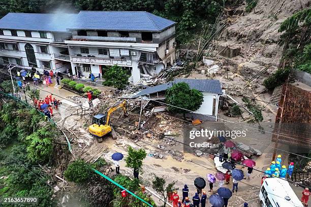 This photo taken on July 28, 2024 shows rescuers working at the site of a landslide in Hengyang, in central China's Hunan province. A landslide...