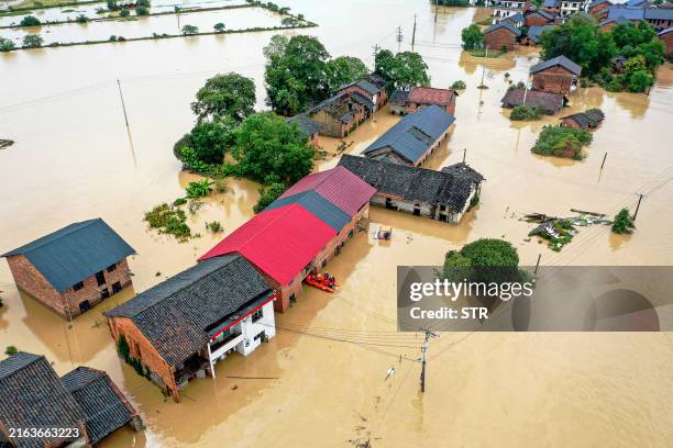 This aerial photo taken on July 28, 2024 shows a flood-affected village following heavy rains caused by Typhoon Gaemi in Zixing, in central China's...