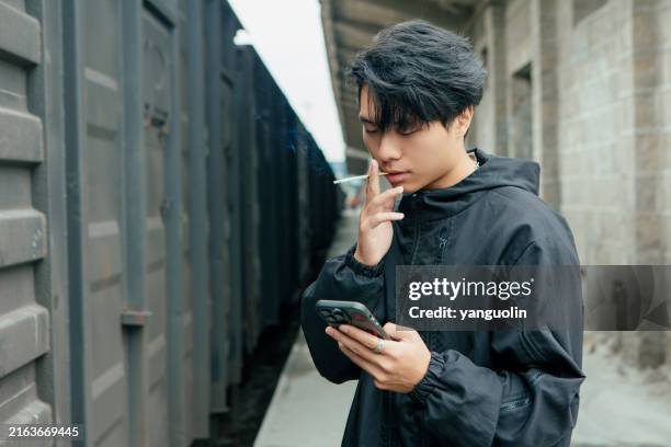 a smoking man in front of the train - asian man smoking stock pictures, royalty-free photos & images