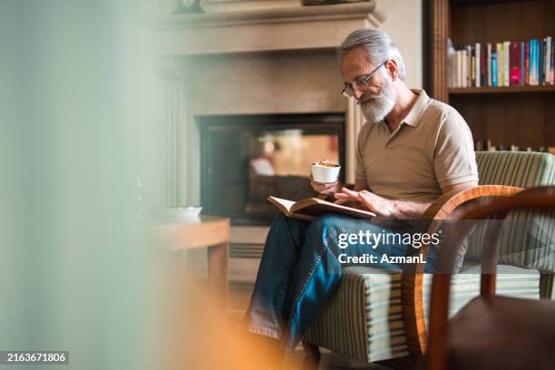 uomo anziano che legge con caffè nella lounge dell'hotel - occhiali da lettura foto e immagini stock