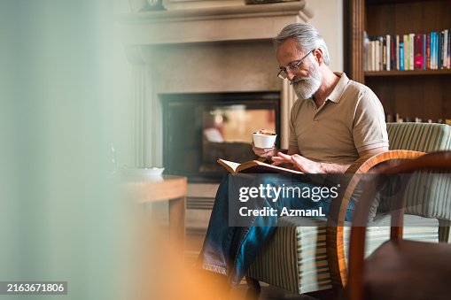 Elderly Man Reading with Coffee in Hotel Lounge Elderly Man Reading with Coffee in Hotel Lounge