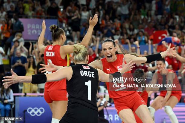 Turkey's Eda Erdem Dundar and Turkey's Gizem Orge celebrate at the end of the women's preliminary round volleyball match between Turkey and the...