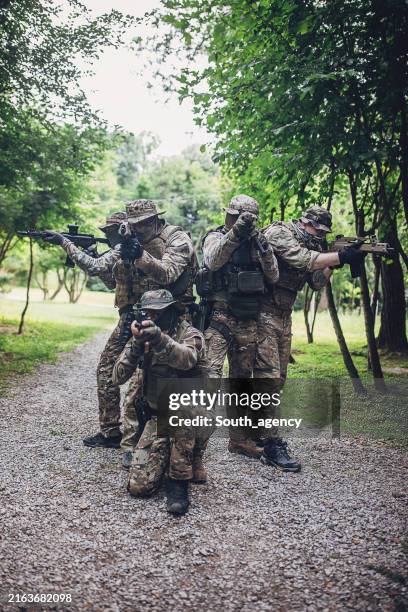 armed squad in camouflage aiming during training - sas 5 5 stock pictures, royalty-free photos & images