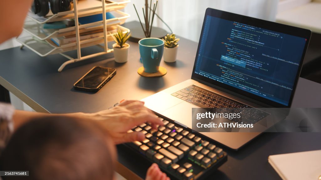 Parent working from home with baby while coding