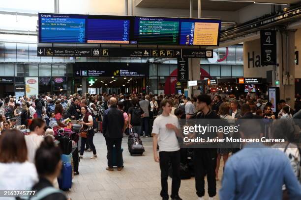 Passengers wait at Gare de Montparnasse after damage to high-speed rail lines caused delays and cancellations on July 26, 2024 in Paris, France....
