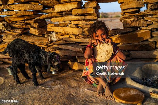 indian little girl eating chapatti, flat bread, desert village - hungry stock pictures, royalty-free photos & images