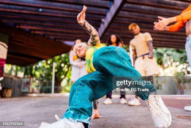 junge frau, die mit freunden im freien tanzt - hip hop stock-fotos und bilder