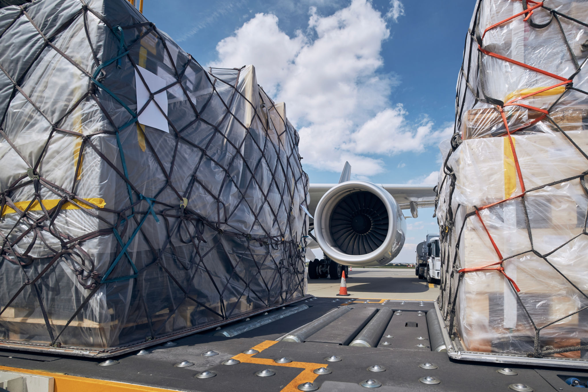 Preparation Before Flight. Loading Of Cargo Containers Against Jet Engine Of Freight Airplane. Preparation Before Flight. Loading Of Cargo Containers Against Jet Engine Of Freight Airplane.