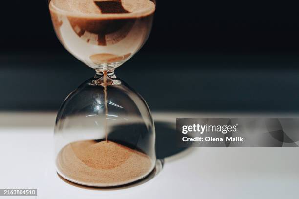 flowing hourglass. time running out - hourglass stock pictures, royalty-free photos & images