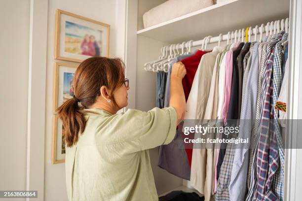 mujer arreglando camisas de hombre en un armario - escaparate fotografías e imágenes de stock