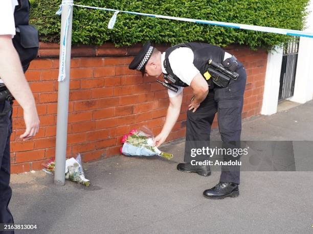 Police officer lays flowers near the scene where an attack at a Taylor Swift themed yoga and dance workshop took place in Southport near Liverpool,...