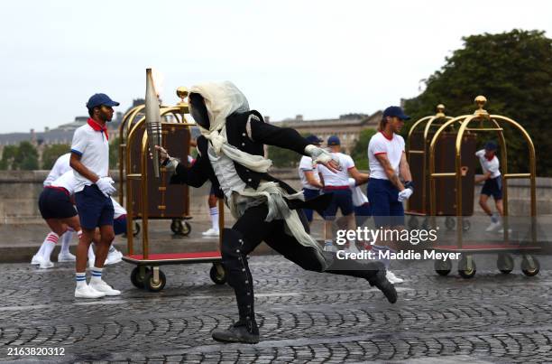 Torchbearer runs past Pont Neuf during the opening ceremony of the Olympic Games Paris 2024 on July 26, 2024 in Paris, France.