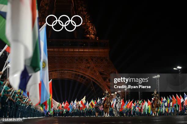 General view as The Horsewoman crosses the Iena Bridge to the Place du Trocadero, as Flags of Competing Nations are presented, as the Olympic Rings...