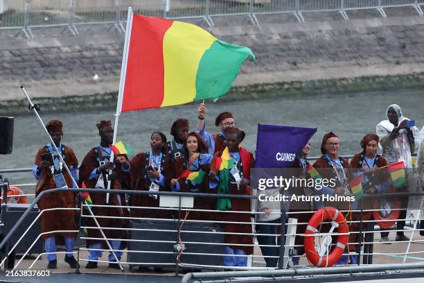 Naby Keita and Fatoumata Sylla, Flagbearers of Team Guinea, are seen on a boat waving their flag along the River Seine during the opening ceremony of...