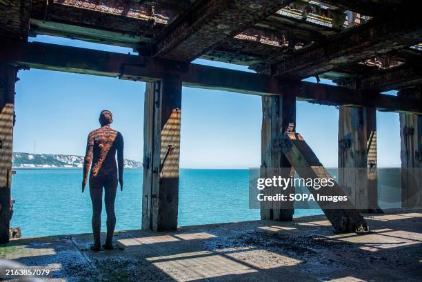 Antony Gormley's haunting life-sized male statue is facing out to the sea from Folkestone Pier. Anthony Gormley is a British artist. His Iron Men...