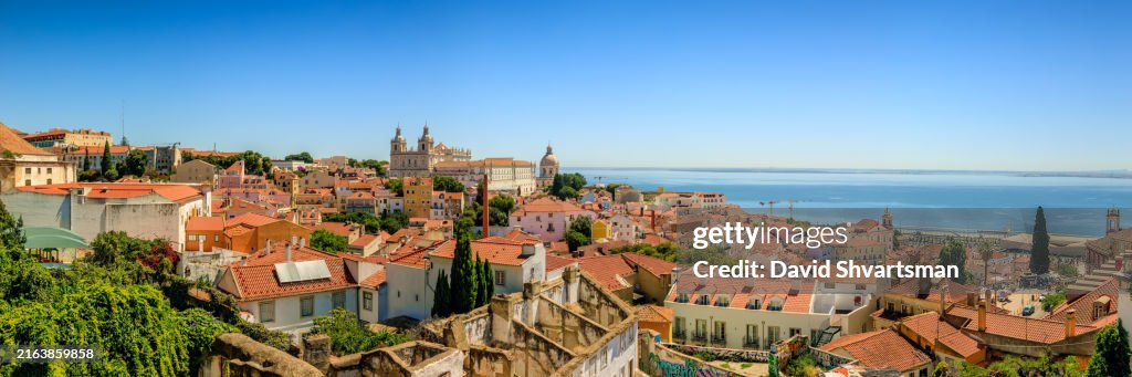 A panoramic view of the rooftops in the Alfama district with a breathtaking panorama over Lisbon - Alfama, Lisbon, Portugal