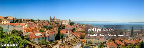 a panoramic view of the rooftops in the alfama district with a breathtaking panorama over lisbon - alfama, lisbon, portugal - lissabon stockfoto's en -beelden