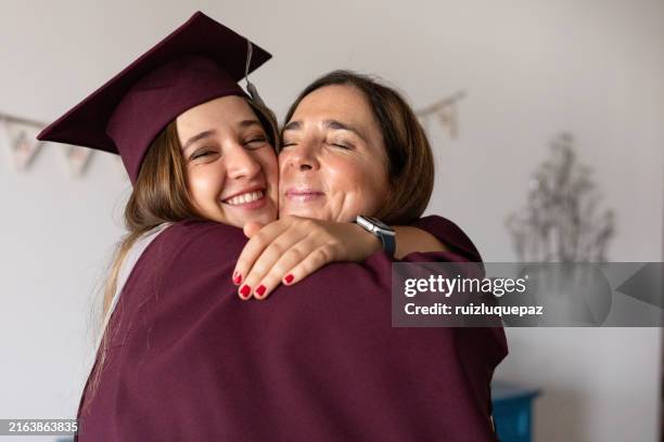 portraits of young female graduate and her mother before the graduation ceremony - laatstejaars high school stockfoto's en -beelden