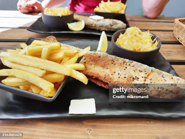 grilled trout fish serve with chips and salad - butter fried potatoes stock pictures, royalty-free photos & images