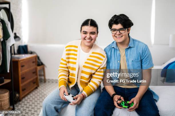 friends playing video game at home - girl and boy playing video games stock pictures, royalty-free photos & images