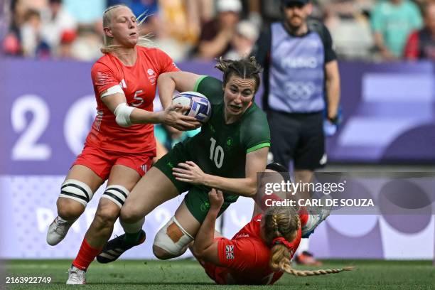 Ireland's Eve Higgins is tackled by Britain's Heather Cowell and Britain's Abi Burton during the women's placing 7-8 rugby sevens match between...