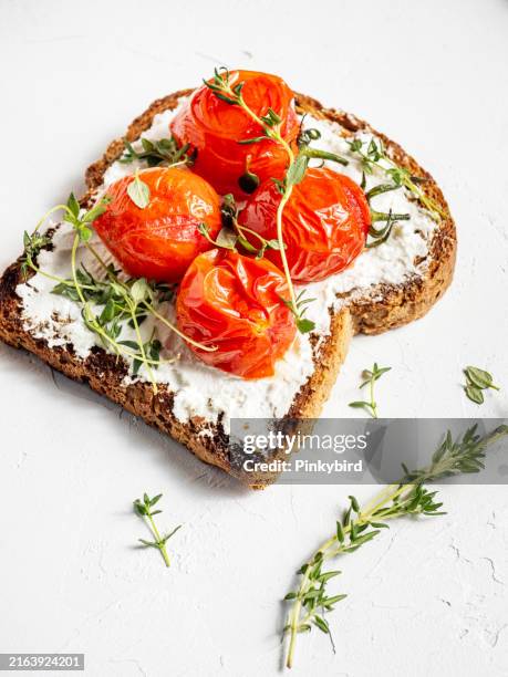 toasted bread with cheese and tomato. crostini. bruschetta. healthy vegetarian toasts with cream cheese and cherry tomato. toasted bread with cheese and roasted cherry tomato. - ciabatta stock pictures, royalty-free photos & images