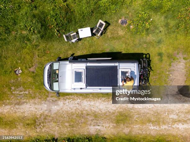 vista de dron de la autocaravana con paneles solares y configuración del campamento - autoconsumo electrico fotografías e imágenes de stock