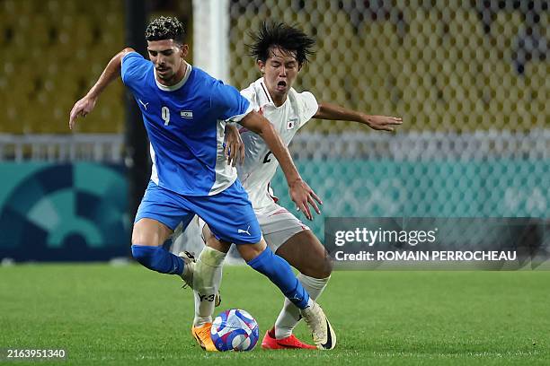 Israel's forward Dor Turgeman is challenged by Japan's defender Kaito Suzuki during the men's group D football match between Israel and Japan during...