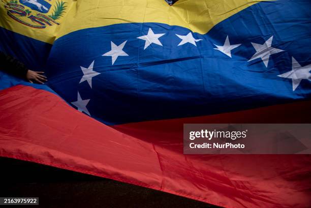 Opponents of Venezuelan President Nicolas Maduro are displaying a Venezuelan flag during a rally called by presidential candidate Edmundo Gonzalez...