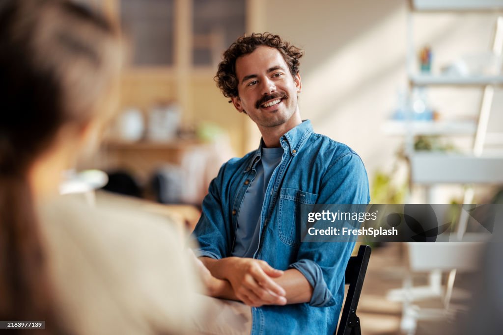 Hombre sonriente participando en una conversación amistosa en el interior