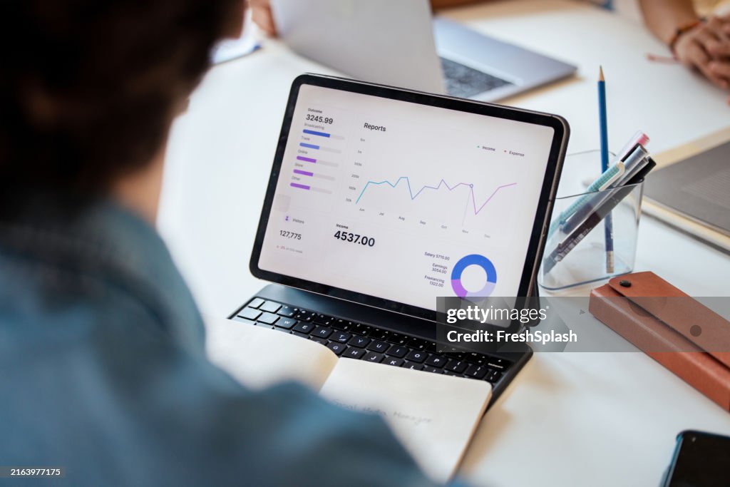 Business Report On Tablet Displaying Financial Data and Charts