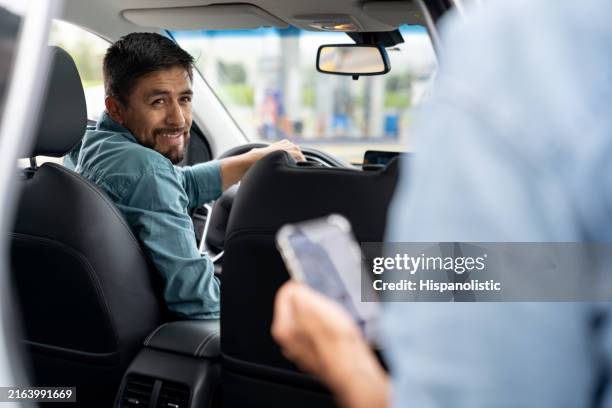 crowdsourced taxi driver picking up a passenger - uber taxi stock pictures, royalty-free photos & images